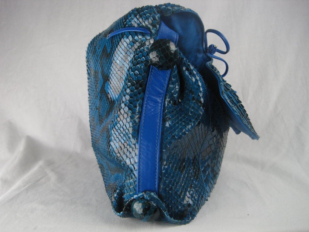 Carlos Falchi handbag made out of royal blue and black snakeskin.  Classic cinched front is tightly gathered with leather tie. Flap opening.  Large snakeskin covered buttons on all four corners. Royal blue leather trim, strap, and interior. 