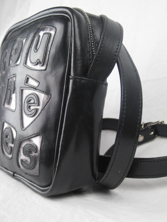 Black leather purse with irregularly shaped clear plastic inserts.  