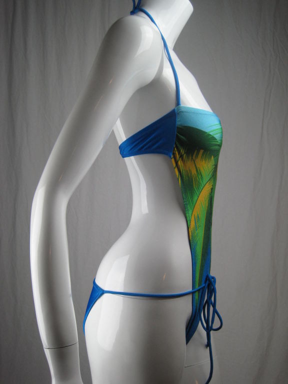 MARKED DOWN FROM $225!

Sexy Gottex swimsuit toes the line between a one-piece and bikini.  Royal blue with abstract palm tree print.  Halter-style ties at back neck.  Strap at bust hooks at center back with plastic closure.  Ties at hip can