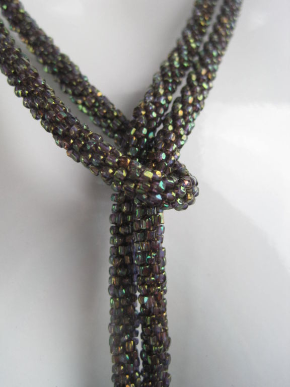 1920's rope necklace. Irregularly shaped iridescent seed beads.  Looped fringe ends.<br />
<br />
Measurement-<br />
<br />
Length: 55