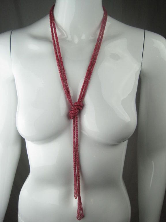 1920's fuchsia sautoir necklace.  Made of cut glass seed beads.  Length affords it to be worn in a variety of styles. Looped fringe ends.<br />
<br />
Length: 75