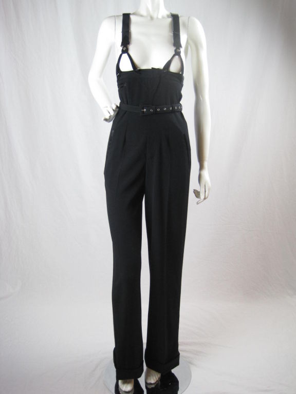 Iconic high-waisted overalls with black tuxedo satin side stripe. Suspenders have elasticized straps, silver hardware, and ends that are lined with black leather.  Suspenders attach to trousers with buttons.  Side pockets.  Center front zip with