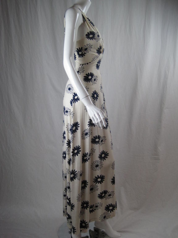 1930's ensemble made of cream colored linen blend with navy daisy print.  Dress is sleeveless, bias cut, snaps at side, and has squared front and back necklines.  Jacket is fitted, above hip length, buttons down center front, and has short sleeves. 
