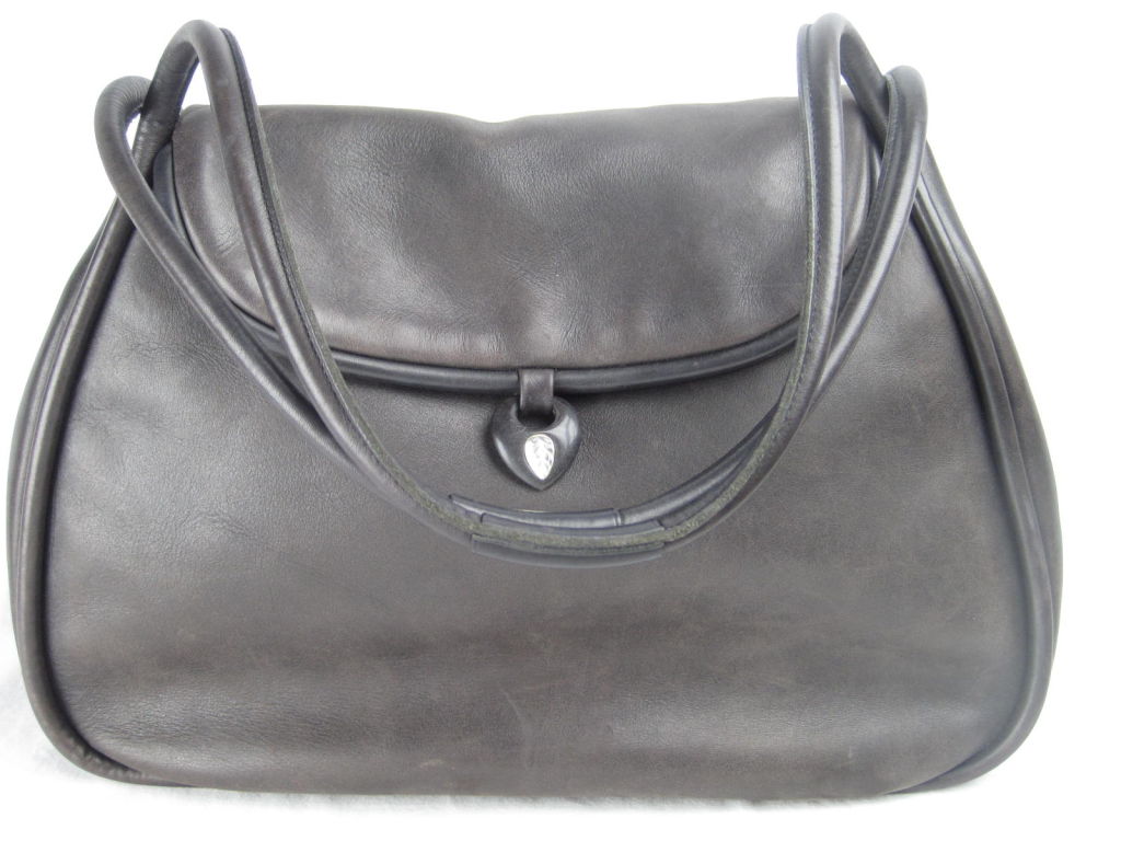 Lalique handbag in extremely soft muted brown leather.  Fold over snap closure.  Leather binding.  Frosted glass leaf just below snap.  Rust colored linen interior with side zip pocket.<br />
<br />
Measurements-<br />
<br />
Handle Drop: 9