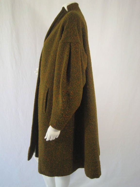 REDUCED FROM $425!

This 1950's swing coat from the Los Angeles designer, Don Loper, is made out of loosely woven, nubby wool tweed in hunter green and rust-colored hues. It is fully lined, has a shawl lapel, center front waist button, side