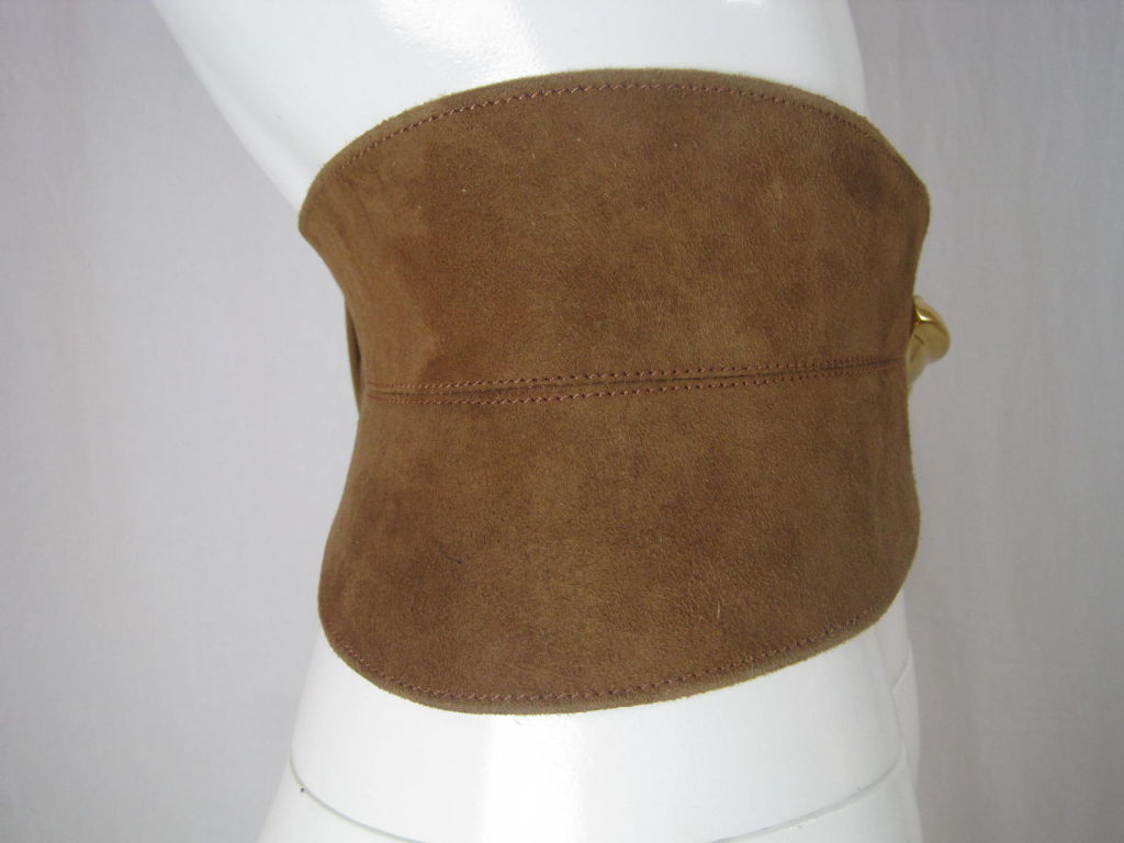 Donna Karan wide cincher belt.  Made of chestnut brown suede.  Gold-toned, organically-shaped hardware.  Elasticized area at center back.  Adjustable.  Topstitched.  Unlined.<br />
<br />
Labeled size 