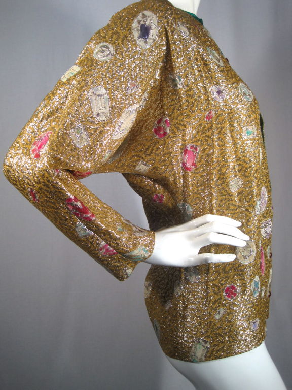 Evening blouse from Lanvin. Faux cardigan look.  Center front fastens with faceted red glass buttons. Green silk charmeuse underneath gold lamé leopard print with various faceted multicolored gems scattered throughout. Crew neck. Long batwing