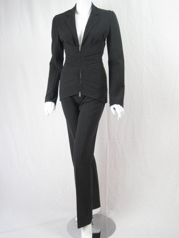 Gray wool pinstriped suit from Gaultier.  Bondage-style bandage wrapped torso.  Lace up back.  Zip front.  Plunging neckline.  Notch lapel.  Narrow, tapered pants with side button closure and grosgrain waistband.  Unlined.<br />
<br />
Labeled