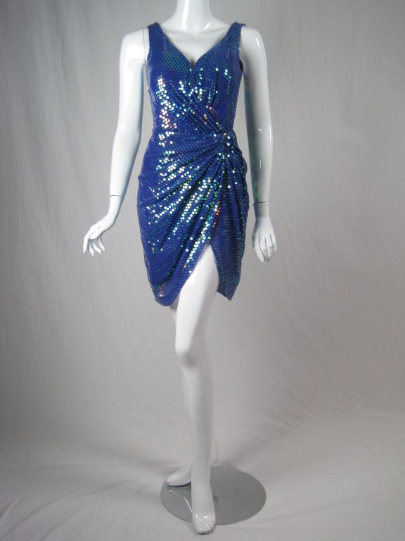 Show-stopping Vicky Tiel cocktail dress.  Blue-violet silk chiffon completely covered with iridescent sequins.  Gathering at left hip.  High slit. V-neck front and back.  Sleeveless.  Lined.  Center back zip.  

No size