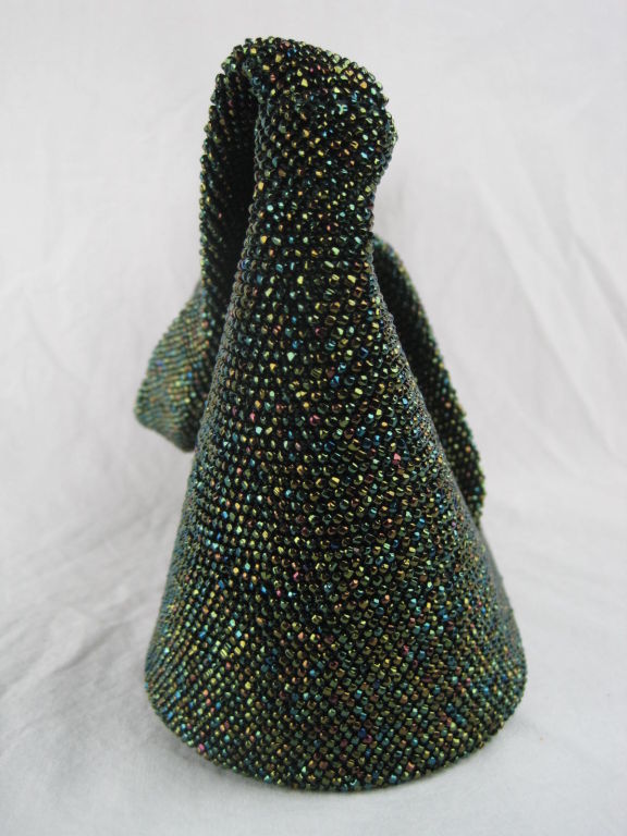 1940's beaded handbag.  Fully covered with iridescent green glass seed beads.  Four fin-like protrusions on front side.  Top opening.  Brown fabric lining.  Single interior side pocket.<br />
<br />
Measurements-<br />
<br />
Length Across Top: