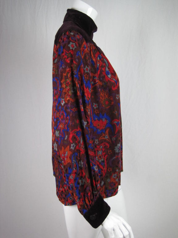 Late 1970's YSL Rive Gauche smock blouse.  Wine-colored silk with an allover paisley pattern.  Aubergine velvet yoke and cuffs.  Silk is gathered below yoke.  Four button closure at left shoulder.  Button cuffs.  Unlined except through yoke.<br