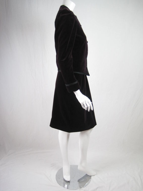 YSL Rive Gauche skirt suit circa late 1970's.  Plum-colored velvet with black soutache trim.  Blazer has round neck, button front, and long sleeves with rolled cuffs and exaggerated shoulders.  Straight skirt has side zip and pockets.  Both pieces