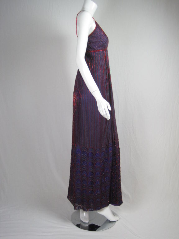 1970's gown from Alfred Bosand.  Purple and gray lace with bright red bugle beads.  Deep v-neck.  Spaghetti straps.  Scalloped lace hem starts at knee and has purple metallic accents.  Center back zipper.  Fully lined.  Skirt lining is cut on the