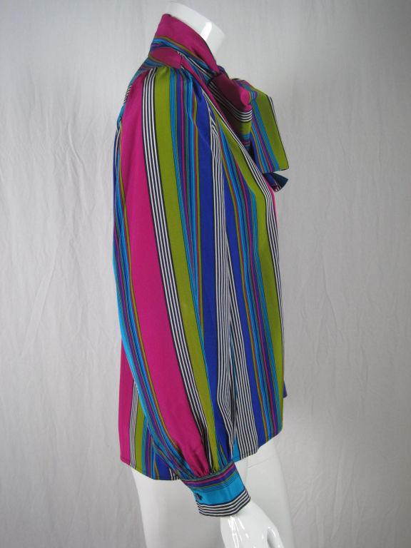 Yves Saint Laurent blouse circa late 1970's through the early 1980's.  Brightly colored striped silk.  Attached ties at collar.  Back yoke with gathers below.  Long sleeves with button cuffs.  Button front.  Unlined.

Labeled size