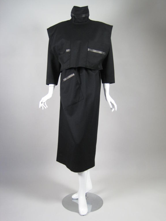 Austere dress from Popy Moreni, which retailed at Neiman Marcus.  Extremely interesting design that seems to have an Asian influence even though the piece was designed and made in France.  High turtleneck.  Three patch pockets with leather detail. 