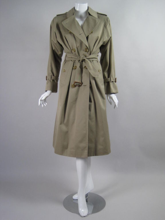 Khaki-colored cotton trench from Burberrys.  Double breasted.  Raglan sleeve with adjustable cuffs.  Turn down collar.  Buttoned rear vent.  Epaulettes.  Nova check wool lining can be unzipped and removed.  2