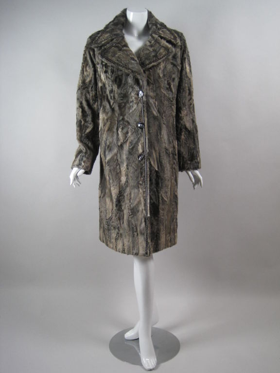 Luxurious pieced lamb's fur coat from Louis Feraud.  Extra wide collar and lapel.  Chocolate brown leather trim.  Mother-of-pearl button front.  Hip pockets.  Fully lined.

No size label.

Measurements:

Bust: 50