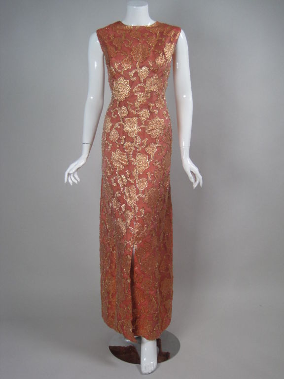 Custom-made gown by French designer Lolita Berdah.  Coral-colored organza jacquard has floral pattern and gold tinsel detail.  Sleeveless.  Round neck.  A-line skirt.  Center front slit.  Fully lined.  Back zip.

No size
