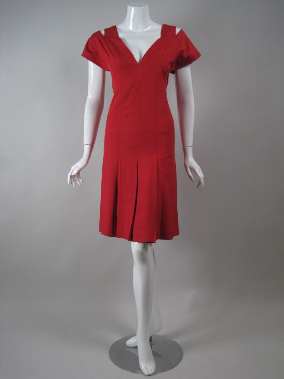 Chanel boutique dress is made out of red silk dupioni.  Short sleeves with open detail at shoulders.  Front and back v-neck.  Crisscrossed bodice.  Skirt's pleats release below the hips to create a flattering silhouette.  Center back zipper with