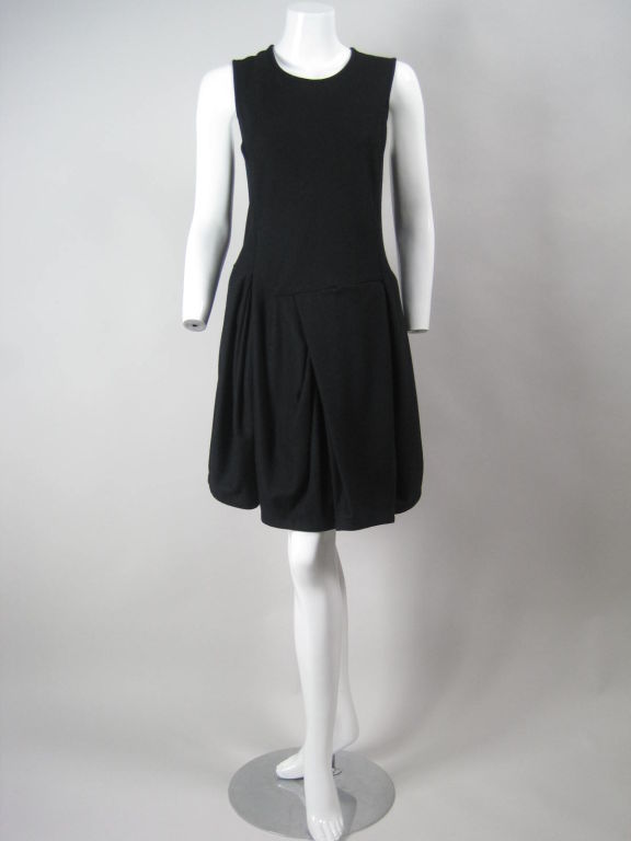 Unique little black dress from Comme des Garcons.  Sleeveless bodice has princess seams and round neckline.  Asymmetrical skirt with uneven diagonal gathering and pleating.  Center back zip.  Unlined.  

Labeled size