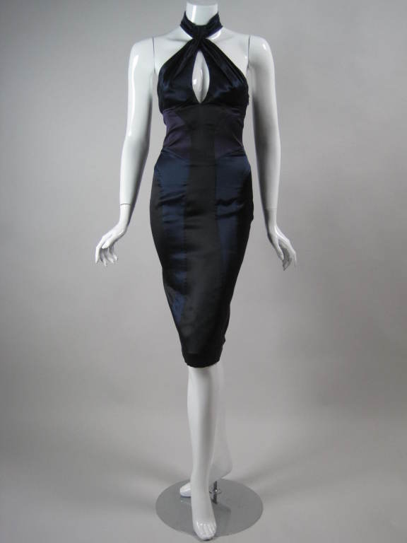 Versace cocktail dress is made out of navy, black, and purple silk spandex.  Clever color-blocking and seaming are very flattering to the figure.  Large keyhole opening at bust.  Open back with crisscrossed detail.  Hook and eye closure at center