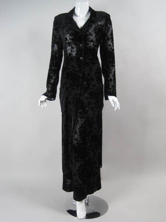 Elegant two-piece ensemble from Sonia Rykiel is made of black velvet with a devore floral pattern.  Long duster is single breasted, has a v-neck with notch lapel, long sleeves, and two patch pockets at hips.  Wide-leg trousers have pleated front,