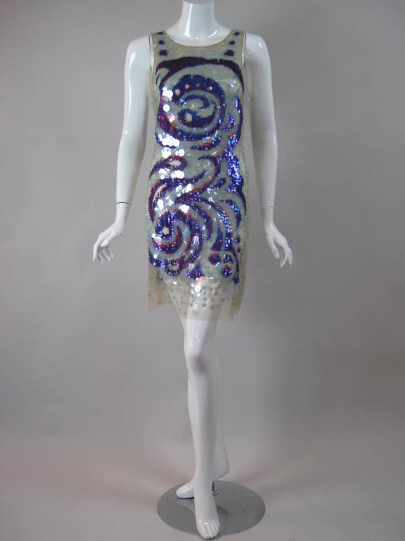 Contemporary cocktail dress from Emilio Pucci is evocative of the aesthetic of the 1960's.  It is made out of nude-colored netting with strategically placed sequins, beading, and paillettes.  Sleeveless.  Scoop neck.  No closures.

No size