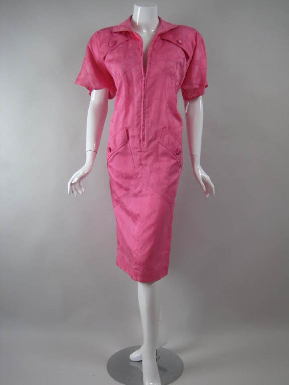 1980's dress from Mila Schon is made out of dark pink polished cotton with oversized dot weave.  Inverted v-shape.  Four diagonal patch pockets with buttoned flap closures.  Short sleeves.  Large shoulder pads.  Center front zip. 