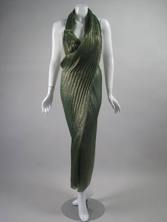 Early 1990's masterpiece by Romeo Gigli is made out of metallic sage green textured fabric.  It has an asymmetrical design that drapes fluidly and allows for a lot of movement.  Dramatic open back.  Three button closure just above left bust. 