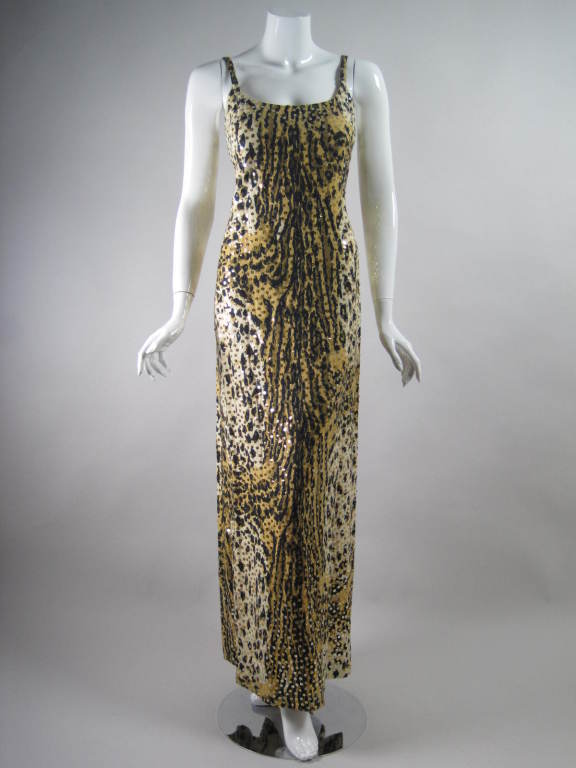 1970's gown and jacket set from Mollie Parnis is made out of leopard-printed cotton and dotted throughout with sequins.  Gown is floor-length, sleeveless, has scoop front and back necklines, and center back zip.  Jacket has no closures and patch