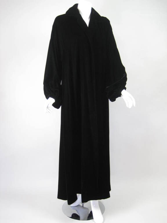 Gorgeous opera coat from Halston is made out of black silk velvet.  Ankle-length.  Long, wide sleeves with snap cuffs.  Turn down collar has three pieces of flexible boning.  No closures.  Fully lined.

Labeled size 8.

Bust: 46