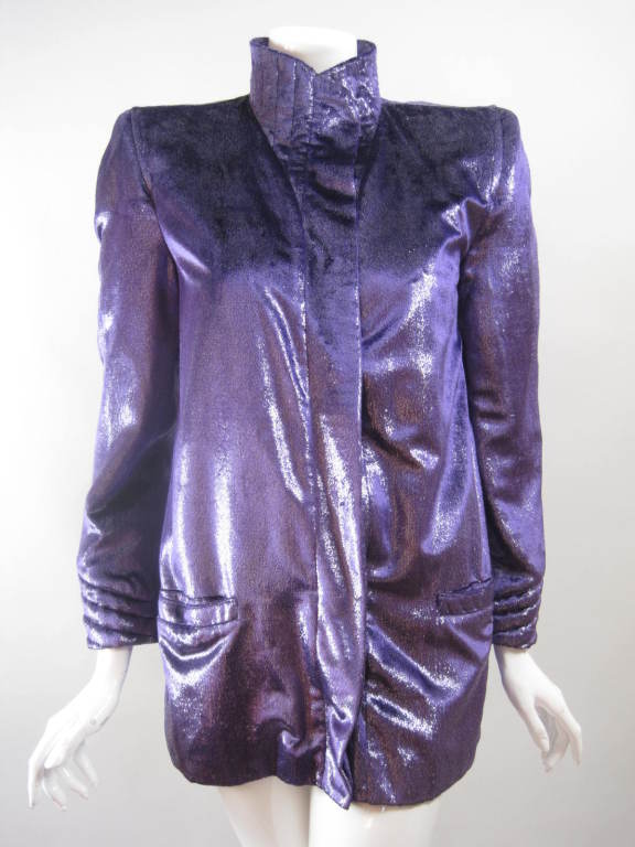 Glam 1980's jacket from Krizia is made out of metallic purple eyelash fabric.  Single-breasted with covered snap closure.  Stand collar has concentric stitching.  Structured shoulders.  Long sleeves with button cuffs.  Welt pockets at hip.  15