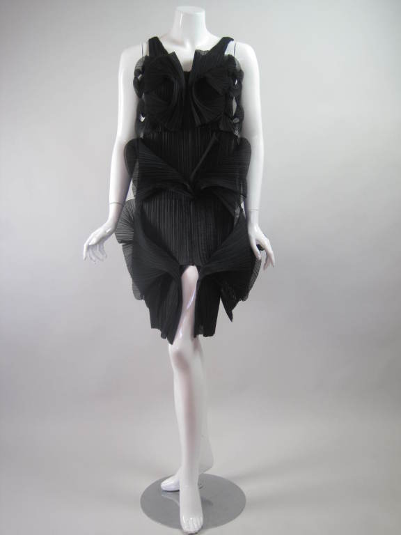 From Issey Miyake's Fall/Winter 2007 Collection comes this amazing sculptural dress.  It is made out of finely pleated black polyester with curving fin-like protrusions that are attached at the center front, side, and center back seams.  V-neck. 