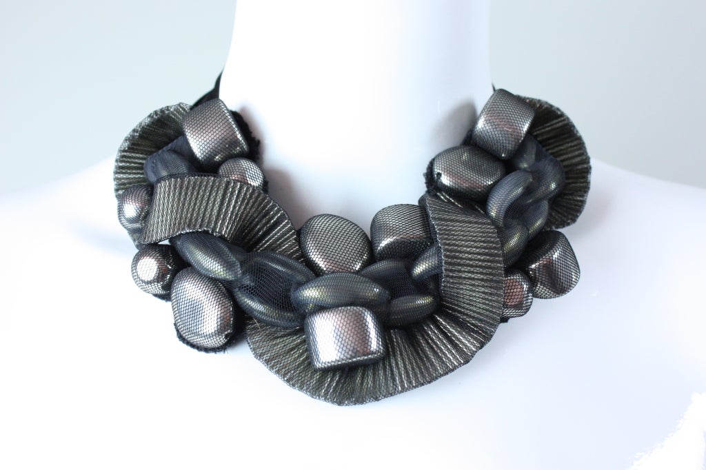 Statement necklace from Oscar de la Renta is made out of a wide gunmetal gray chain centerpiece that is flanked by large chunky silver beads.  A wide strand of bugle beads are woven throughout.  All beads have been covered with fine black netting. 
