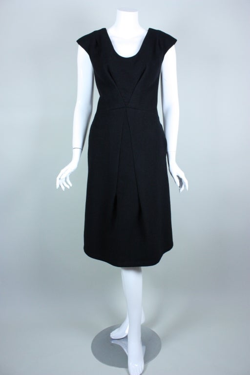 Contemporary dress from Marc Jacobs is made out of soft black cashmere and has a very sculptural feel.  Scoop neck is trimmed with black bugle beads. Cap sleeve.  A-line skirt.  Dress is shaped by four diagonal darts, all of which have the center