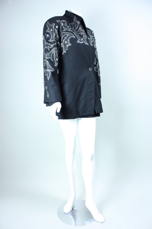 Two-piece dress and jacket ensemble from iconic Italian designer, Byblos, dates to the 1980's.  The jacket is single-breasted, has shawl lapel that stands upwards, long dolman sleeves, single button closure, and slanted hip pocket.  The mini dress