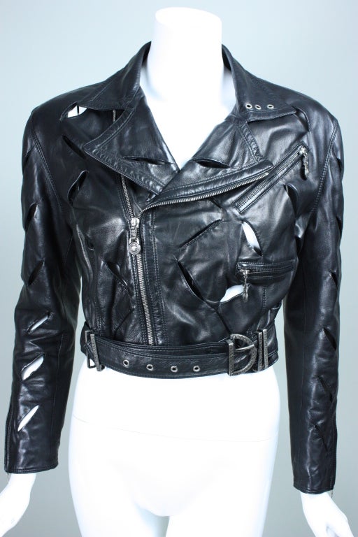 Rare early 1990's motorcycle jacket from Gianni Versace is a iconic example of his work. It is made out of buttery soft leather that is slashed throughout. Front zip closure. Back waist is lightly padded and stitched in horizontal rows.  Built-in