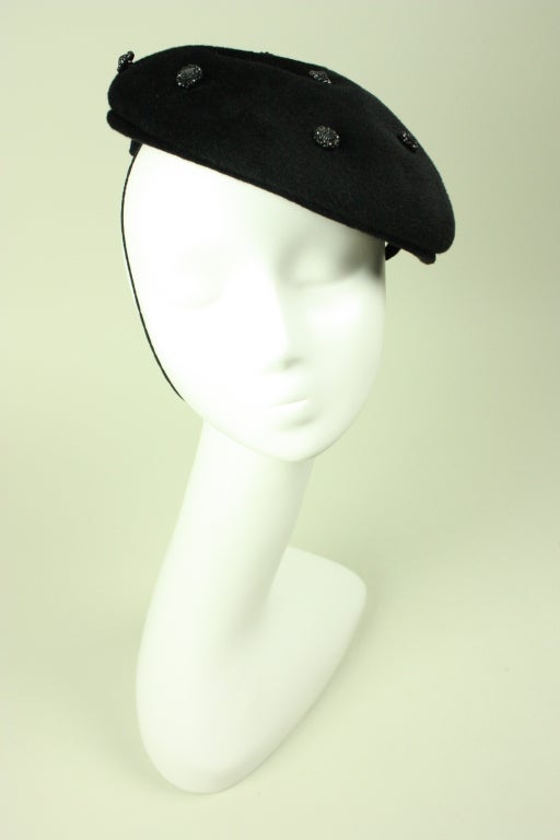 Christian Dior-New York beret dates to the 1960's.  It is made out of soft black felt with black faceted buttons sewn throughout.  Interior grosgrain hatband.  Unlined.  Elasticized chin strap.


Interior Circumference: 20 1/2