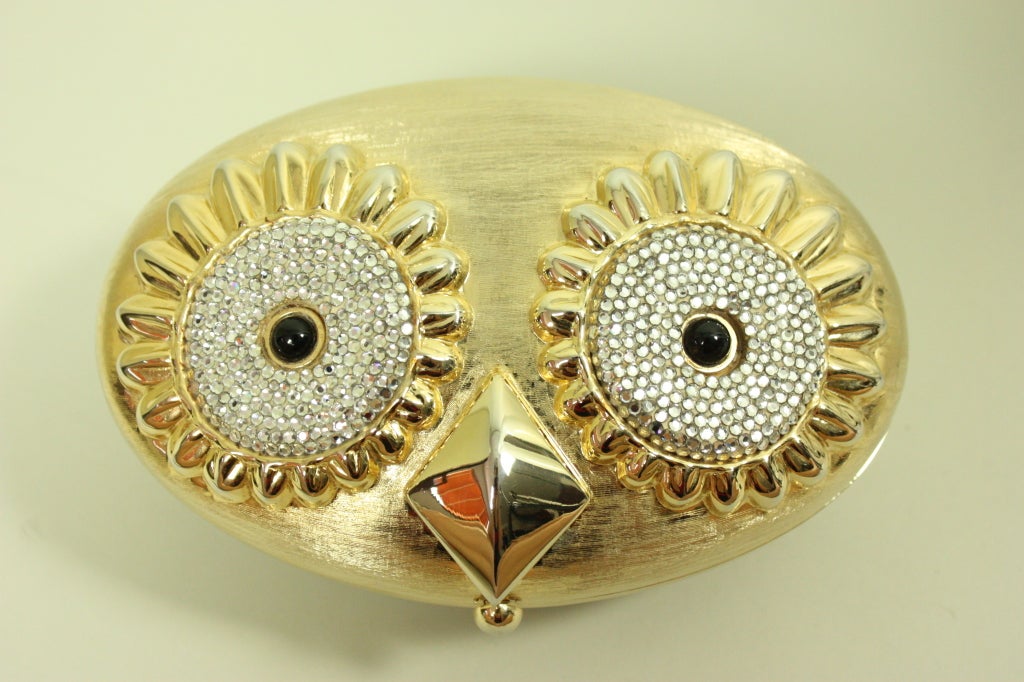 Whimsical clutch from Judith Leiber is made to look like an owl with extra large eyes that are encrusted with crystals.  Interior is lined with gold leather and has two compartments.  Can be worn with optional chain.

Width: 3 1/4