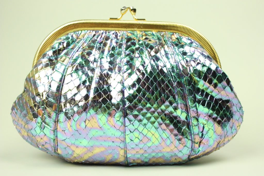 Iridescent snakeskin evening bag from Judith Leiber can be worn either as a clutch or around the shoulder. Gold-toned frame and chain. Kiss clasp is set with semi-precious stones.

Measurements-

Width: 4 1/2-8 1/2
