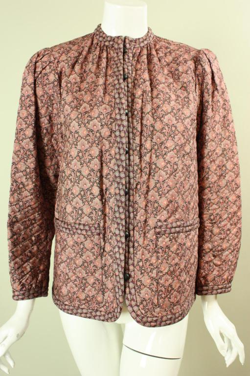 Quilted YSL jacket dates to the late 1970's through early 1980's.  It is made out of soft cotton that features a dense floral print in various shades of pink and mauve.  It is single-breasted, patch pockets at hips, and has looped center front