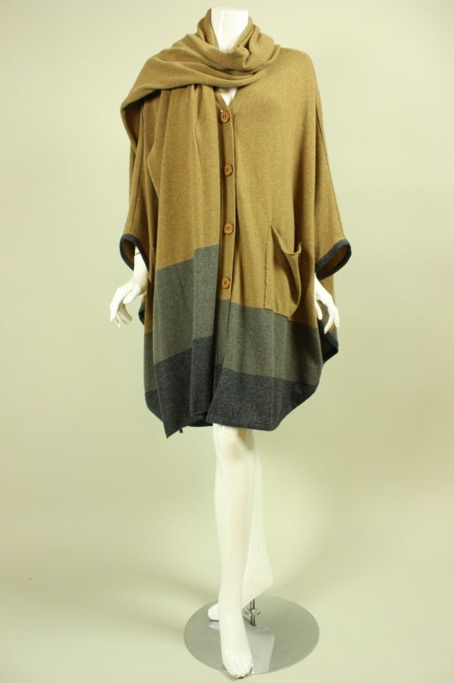 Stunning winter set from Stella McCartney is made out of taupe cashmere with gray bands at hem.  Poncho-shaped cardigan has button front, v-neck, and patch pockets.  Wide scarf can be worn a variety of ways.  Both pieces are unlined.

Labeled size