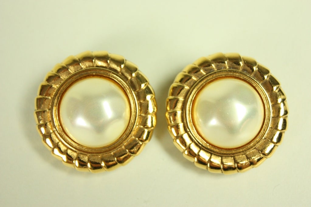 Beautiful earrings from Chanel are made from large costume pearl domes amid gold-toned metal.  Clip-on.

Diameter: 1 1/4