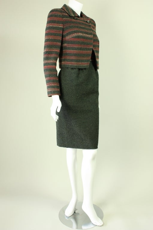 Smart dress and jacket ensemble is made of silk and wool boucle.  Fitted dress has a short-sleeved silk bodice and olive wool boucle skirt.  Waist-length jacket has turn down collar with double button closure at neckline.  Both pieces are