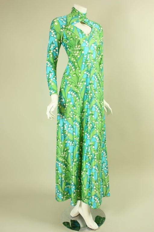 1970's gown from Robert David Morton is made of light blue jersey with a green and white floral print.  Mock neck with diamond-shaped opening below.  Long tapered sleeves.  A-line skirt.  Center back zipper.  Unlined.

No size label.