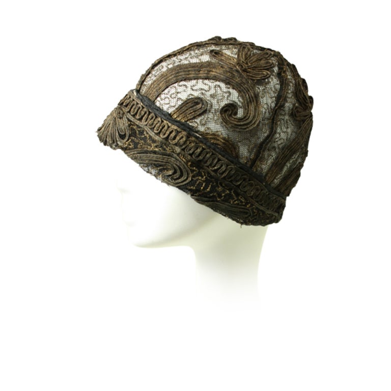 Beautiful cloche dates to the 1920's and is made of gold bullion sewn onto metallic lace.  Bullion is arranged in a scrolling floral pattern.  Unlined.

Interior Circumference: 20 3/8