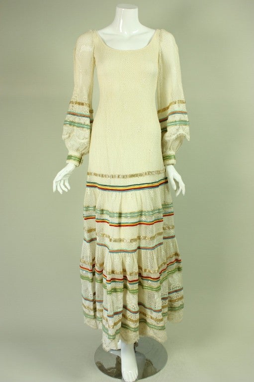Giorgio di Sant'angelo dress dates to the 1970's and is made of an ivory knit.  Bands of multi-colored ribbon are sewn onto the skirt and on the sleeves.  Deep scoop neck.  Lined.  Center back zipper.

Labeled size 6.

Measurements-

Bust: