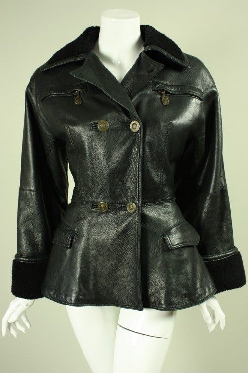 Double-breasted jacket from Gianni Versace likely dates to the 1990's.  It is made of supple black leather with fleece at the cuffs and neckline.  Double breasted.  Medusa stamped buttons.  Lined.

No size label.

Measurements-

Bust: