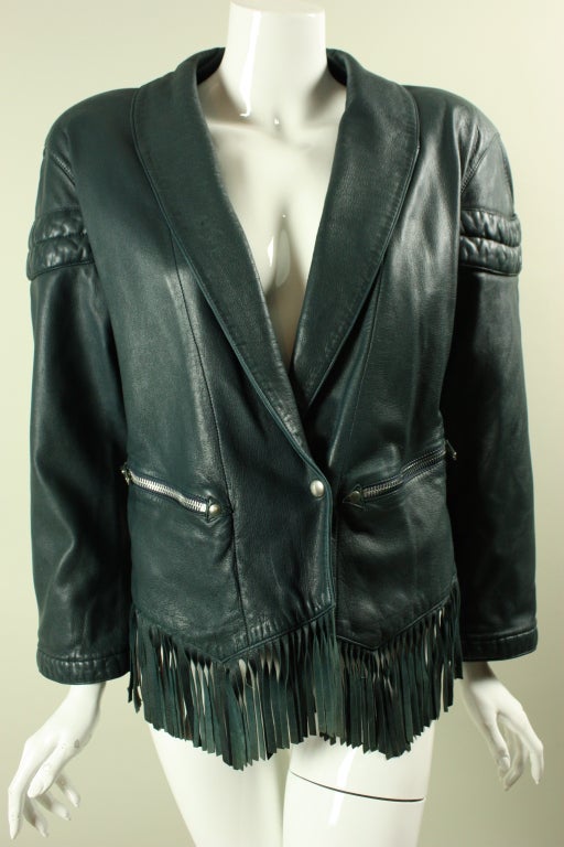 Claude Montana for Idéal Cuir jacket is made of dark green leather and dates to the 1980's through 1990's.  It features a shawl lapel, zippered pockets, and buckle back.  A row of fringe trims the bottom edge.  Lined.

No size