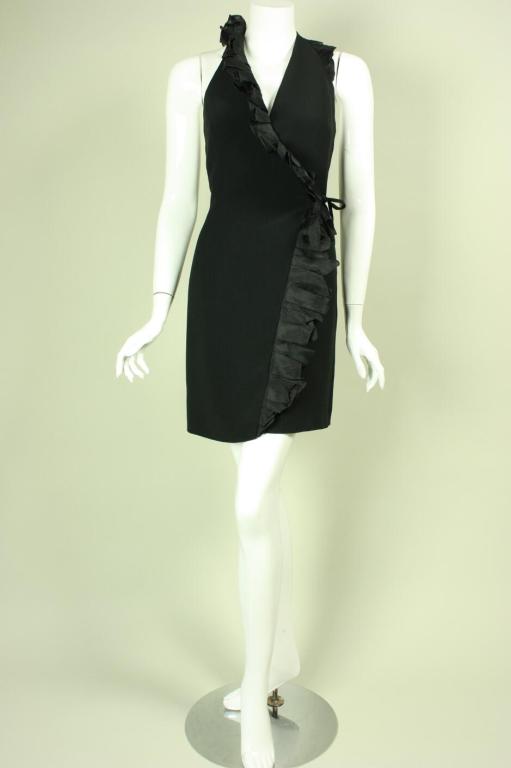 Little black dress from Moschino Couture dates to the 1990's.  It has a wrap front with side tie and a ruffle that extends from the left side waist to the right armhole.  Fully lined.

Labeled US size 8.

Measurements-

Bust: 34-36